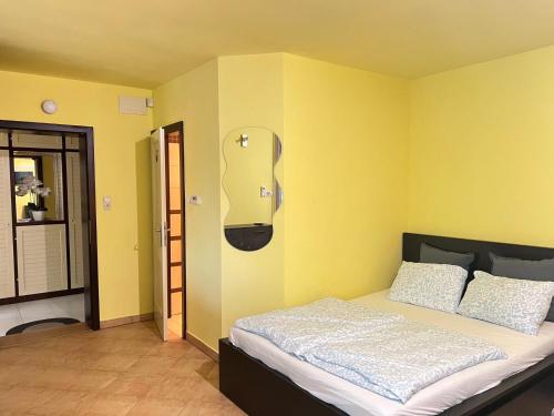 a bedroom with a bed with yellow walls at Sailor's Apartman in Siófok