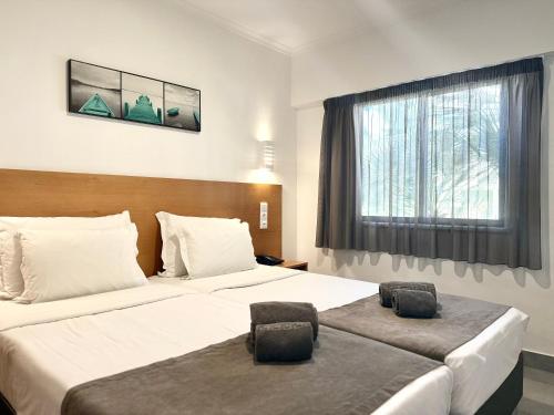 a hotel room with two beds and a window at Bayside Salgados in Albufeira