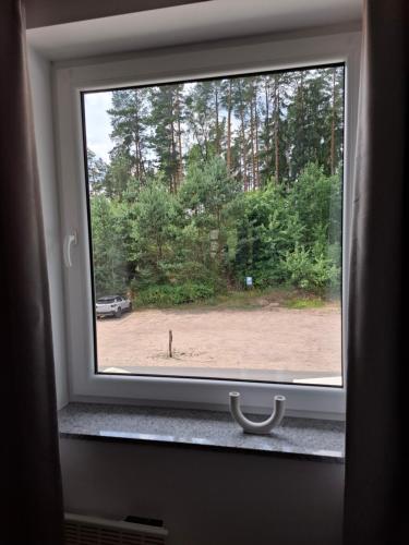 a window with a view of a field and trees at Apartamenty Młyn in Męcikał