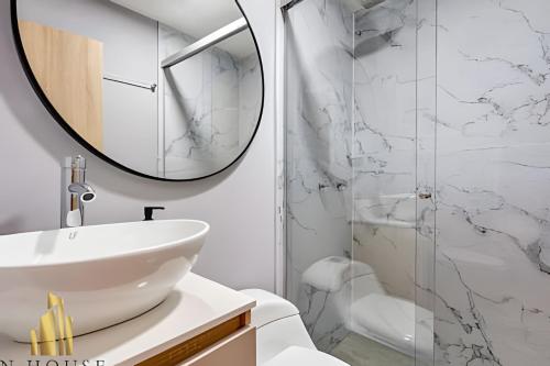 un bagno con un lavandino bianco e uno specchio di Aria Living 401 - Sophisticated Living in Laureles a Guayaquil