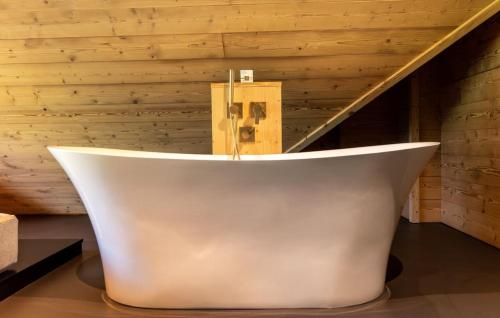 a white bath tub in a room with a wooden wall at Hotel Spielmann in Ehrwald