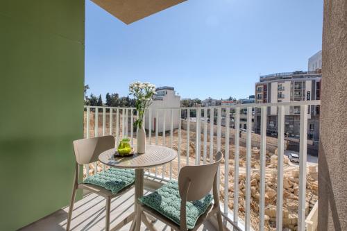 a balcony with a table and chairs and a view at Luxury Apartment Heart of St Julians Sleeps 5 in San Pawl il Bahar
