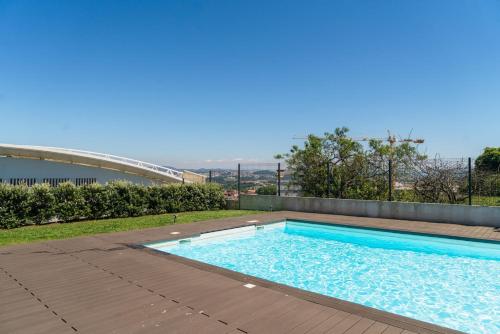 a swimming pool on the roof of a house at Studio w/ Balcony, Pool & Gym | Antas by Host Wise in Porto