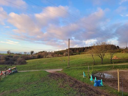 a grassy field with a dirt road and power lines at Kermarc'heg in Guerlesquin