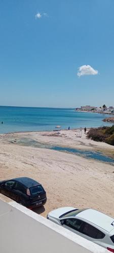 two cars parked on a beach next to the ocean at Kelibia - Villa La Marsa plage in Kelibia