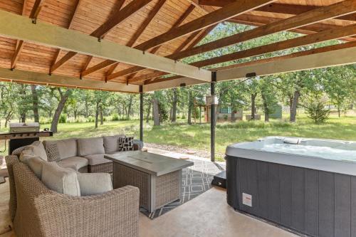 a patio with a hot tub and a table and chairs at Pecan Farm Haus in Fredericksburg