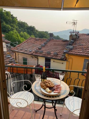 a table with a plate of food and wine on a balcony at Casa Lizluba in Montefegatesi