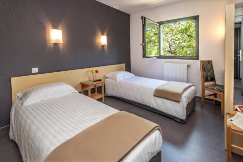 Cette chambre comprend 2 lits et une fenêtre. dans l'établissement Hotel Eco - A75, à Banassac