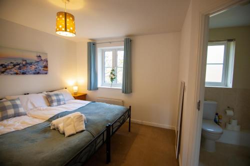 a bedroom with a bed and a window and a toilet at Picket House - Andover in Andover