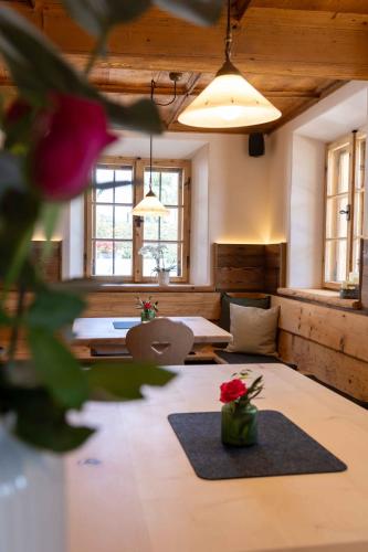 a room with two beds and a table with flowers at Hotel und Landgasthof Zachschuster in Gaißach