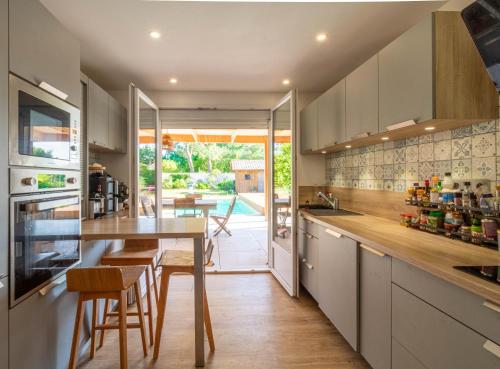 une cuisine avec une table et des chaises ainsi qu'une salle à manger dans l'établissement La Case d'Elista, à La Teste-de-Buch