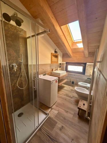a bathroom with a shower and two sinks and a toilet at Méijòn Lo Brenlo in Courmayeur
