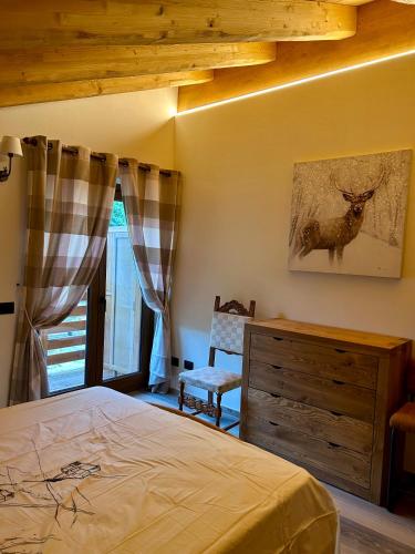a bedroom with a bed and a dresser and a window at Méijòn Lo Brenlo in Courmayeur
