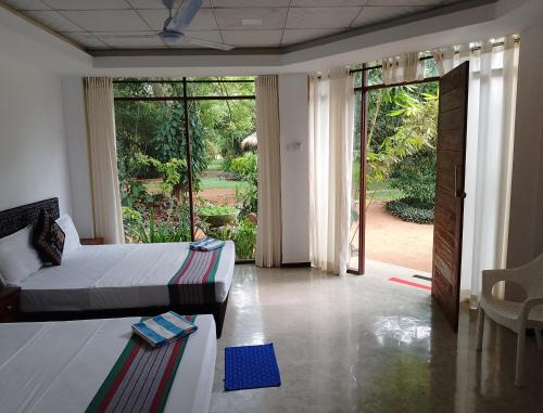 a bedroom with a bed and a large sliding glass door at Sudunelum Holiday Resort in Anuradhapura
