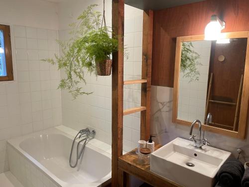 a bathroom with a tub and a sink and a bath tub at Les ptis chiffons in Lacanau