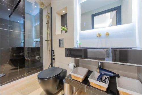 ein Bad mit einem schwarzen WC und einer Glasdusche in der Unterkunft Hôtel particulier Marceau - Centre - Neuf - Suites de 3 à 28 chambres in Cannes