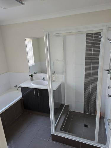 a bathroom with a shower and a sink and a mirror at Seaviews in Lancelin