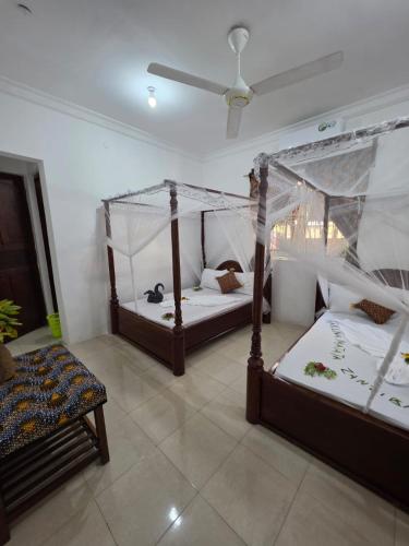 a bedroom with two beds and a ceiling at Kite Active Paje in Paje