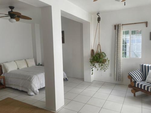 a white bedroom with a bed and a couch at Captain All's BED AND BREAKFAST in Sabana Grande de Palenque