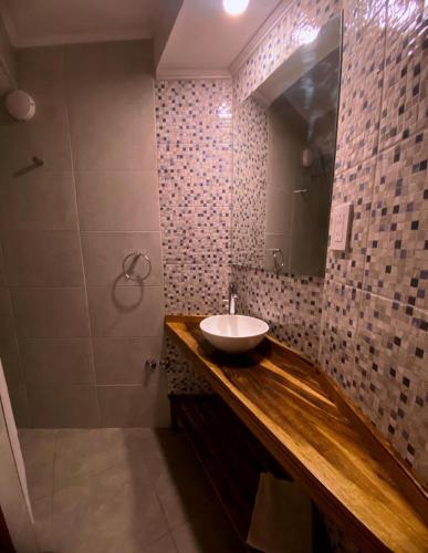 a bathroom with a sink and a mirror at Cabañas Villa de Luján in San Rafael