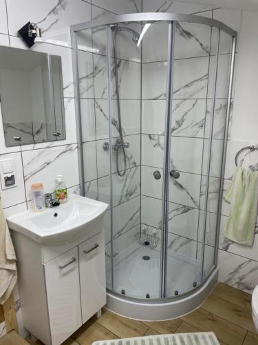 a bathroom with a glass shower and a sink at Letnisko na Pierkunowie in Giżycko