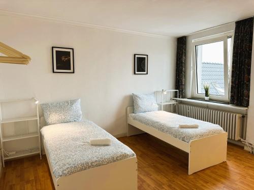 a room with two beds and a window at Handwerker Residenz Plus in Lengerich