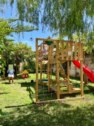 a wooden playground with a slide and a swing at Casina Colosso - relais&more - in Nardò