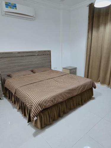 a bedroom with a bed with a brown comforter at رحاب السعاده rehab alsaadah apartment in Salalah