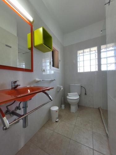 a bathroom with a red sink and a toilet at Apartamentos Cas Xurrac in Es Calo