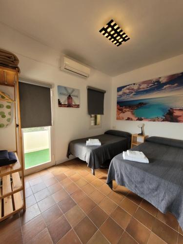 a room with two beds and a window at Apartamentos Cas Xurrac in Es Calo
