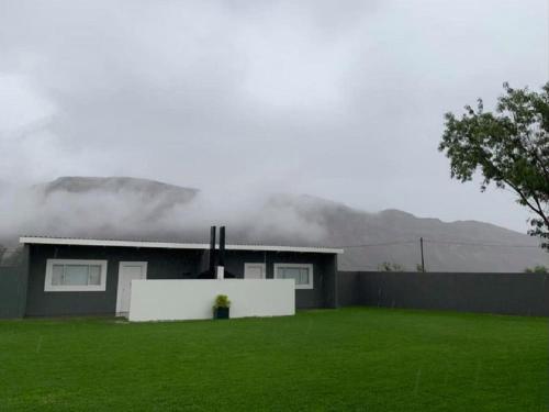a house with a green lawn in front of it at Noordoewer Self Catering Chalets in Noordoewer