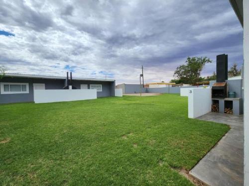 a large backyard with a yard with green grass at Noordoewer Self Catering Chalets in Noordoewer