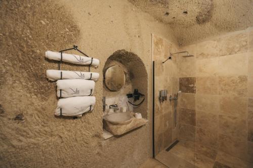 a bathroom with a shower and a sink and towels at Vie Cappadocia - Adults Only in Nevsehir