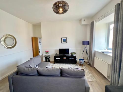 a living room with a couch and a television at Central Apartment Linlithgow in Linlithgow