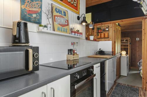 a kitchen with a counter top with a microwave at Woodside Lodge Cenarth in Cenarth