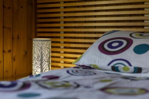 a bedroom with a bed with a pillow and a lamp at Woodside Lodge Cenarth in Cenarth