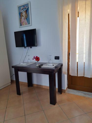 a wooden table in a room with a television at Mermaid Hotel Vlore in Vlorë