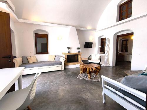 a living room with a couch and a fireplace at Navita Cave Houses in Fira