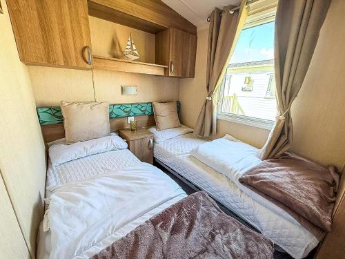 een kleine kamer met 2 bedden in een caravan bij Lovely 8 Berth Caravan At California Cliffs, Near Scratby Beach Ref 50046L in Great Yarmouth