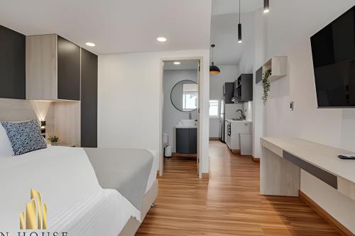 a bedroom with a white bed and a kitchen at Aria Living 501 - Design and Perfect Location in Guayaquil