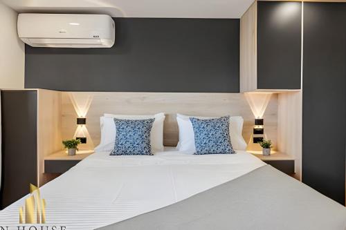 a bedroom with a large white bed with blue pillows at Aria Living 501 - Design and Perfect Location in Guayaquil
