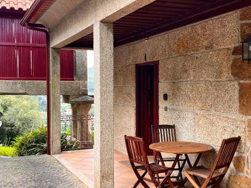a table and chairs sitting on a patio at Nomad's Country - Casa Cimo de Vila in Pedraça