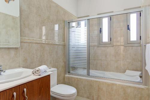 ein Badezimmer mit Toilette, Waschbecken und Dusche in der Unterkunft Luxury Coral Bay Villa Villa Shanta 3 Bedroom Villa Distant Sea Views in Peyia