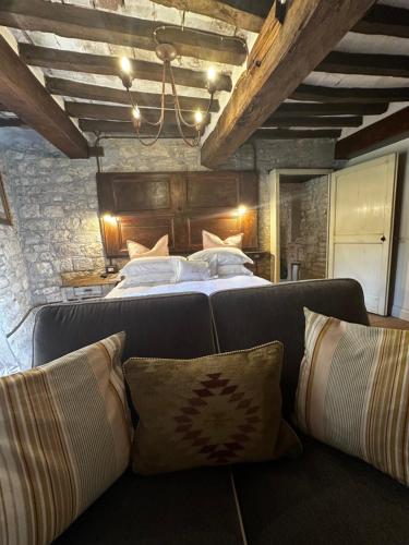 a bedroom with a bed and a couch with pillows at Nido di Gufi in Todi