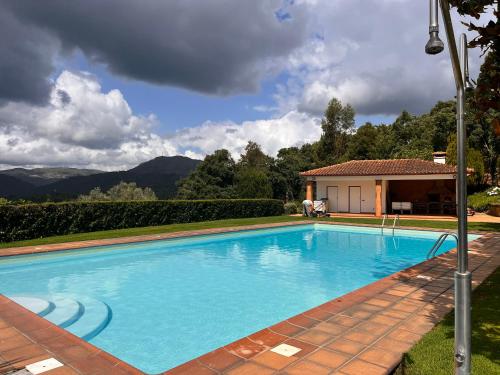 a large blue swimming pool in front of a house at Nomad's Country - Casa Cimo de Vila in Pedraça