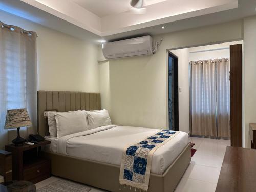 a bedroom with a bed and a table with a lamp at Hotel The Grand Hyatt Dhaka in Dhaka