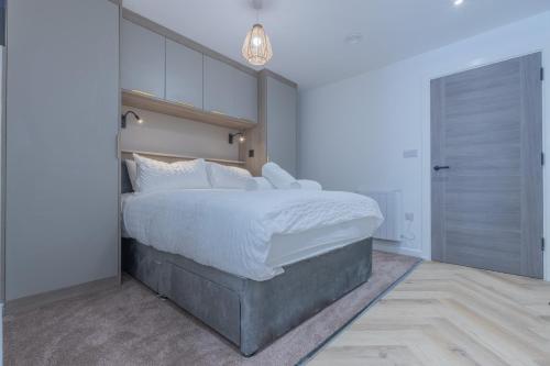 a bedroom with a large bed with white sheets at Unit 3 Sleek 1-BR Stays, Near Sheffield United Football Club, Fast Wi-Fi, Parking in Sheffield