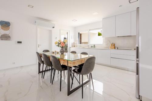 Una cocina con mesa de comedor y sillas. en Villa Atlantica One luxury and unique with ocean view, en Lourinhã