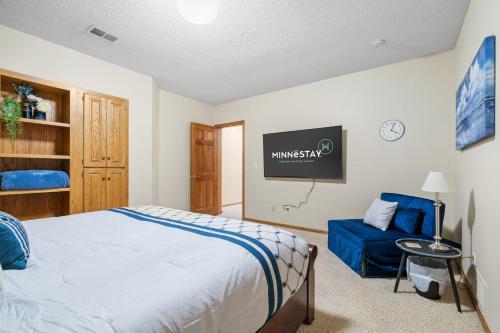 a bedroom with a bed and a blue couch at Serenity on the Creek in Eden Prairie