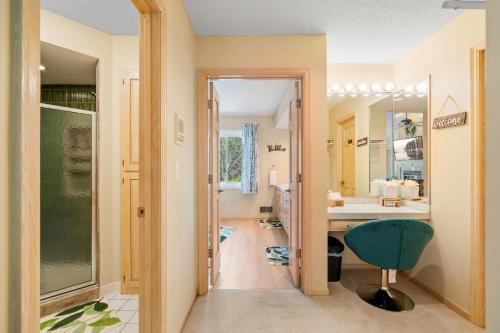 a hallway with a bathroom with a sink and a chair at Serenity on the Creek in Eden Prairie